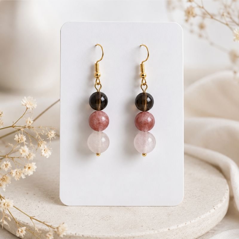 Radiant Heart Crystal Earrings featuring natural Smoky Quartz, Sunstone, and Rose Quartz beads with gold-tone hooks displayed on a white jewelry card.